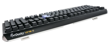 An angled view of a Ducky One 3 - Classic Black / White Nordic - Fullsize - Cherry Red mechanical keyboard with black keys on a white background.