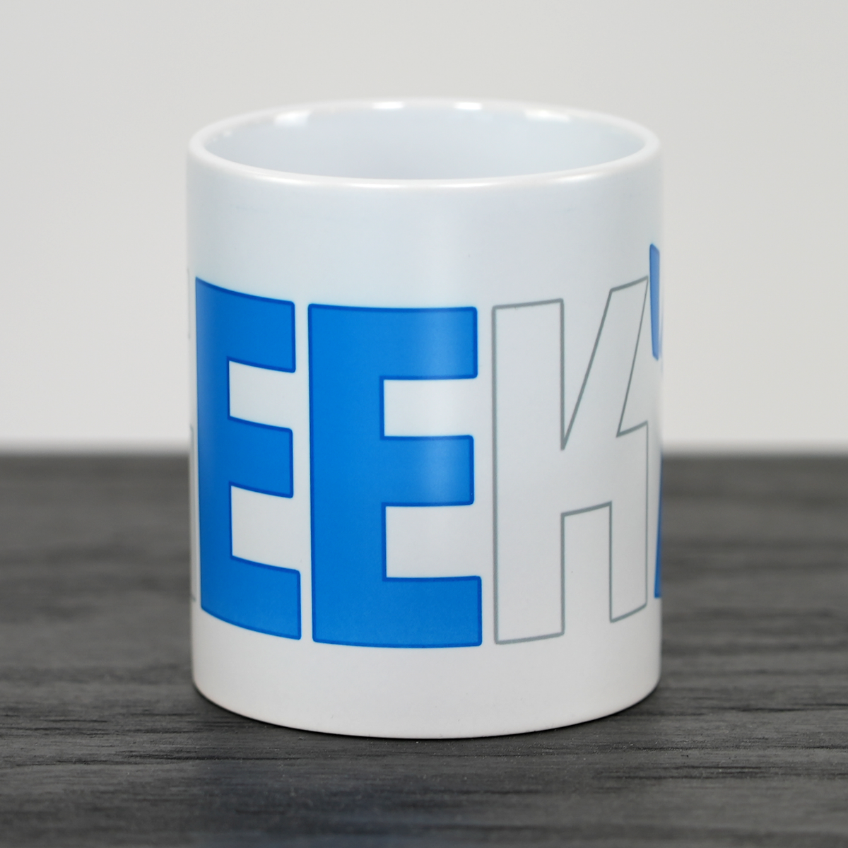 Nærbillede af blåt og hvidt Geekd-logo på hvid kop