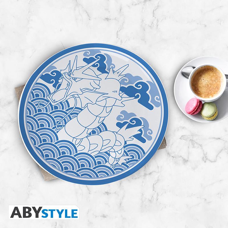 Blå Pokémon-tallerken med Gyarados-motiv på bord ved siden af kaffe