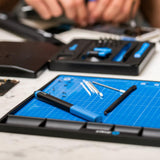 Nærbillede af iFixit FixMat med reparationsværktøj på arbejdsbord